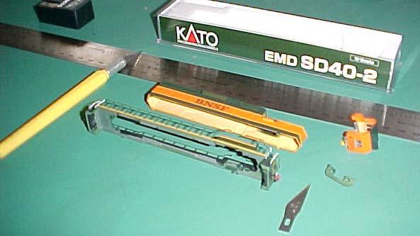 The picture above shows our work station, which is a large self healing cutting board. A large metal ruler, the knife with the # 11 blade and the model, in this case, the SD 40-2 in N scale are ready.