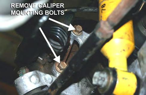 27. If trimming is necessary, unbolt the two (2) mounting bolts [older spindles have three (3) bolts] and remove the dust shield.