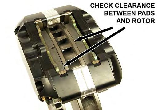Slide the pad retaining clip through the provided holes in the caliper and brake pads.