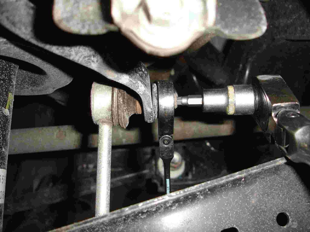 3. Disconnect the sway bar end link from the sway bar by using a 14mm open end wrench and a 5mm