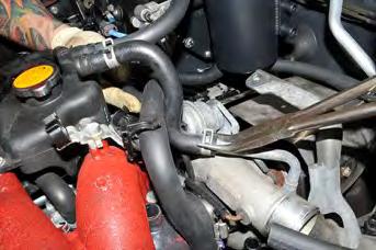 Remove the upper OEM coolant line pinch clamp and pull the OEM line off the