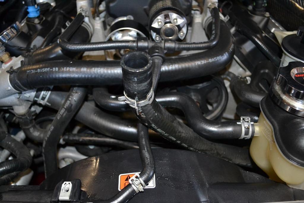 7. Once bolts are removed, lift the tank off the vehicle enough to remove the coolant line attached to the bottom