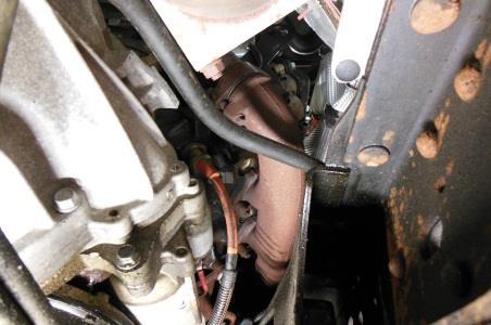 Once the bottom bolts have been removed, from the topside of the engine, loosen and remove