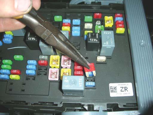 130. Pull back on the two tabs holding the fuse cover to the fuse box and lift the cover out of