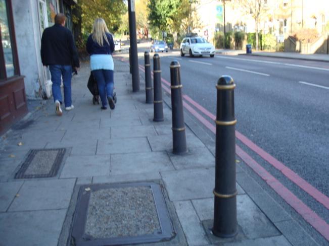 This is because the central bollard houses water meter equipment for the water company and the two adjacent concrete bollards are to