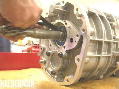 7) What disassembly operation is being performed in the photo below? a. Removing the snap ring retaining the input shaft bearing b. Removing the snap ring retaining the output shaft bearing c.