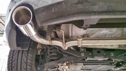 3. Move the mid- section of the COBB Catback Exhaust system in from the back of the vehicle and over the vehicle s rear sub-frame. Re-attach it to the factory exhaust hangers.