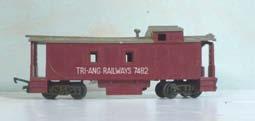 3.132 Tri-ang R115 bogie Caboose, maroon with grey roof, lettered 'Tri-ang Railways 7482' in white on each side. No shield. Stove chimney and all steps intact. Tension-lock couplings.
