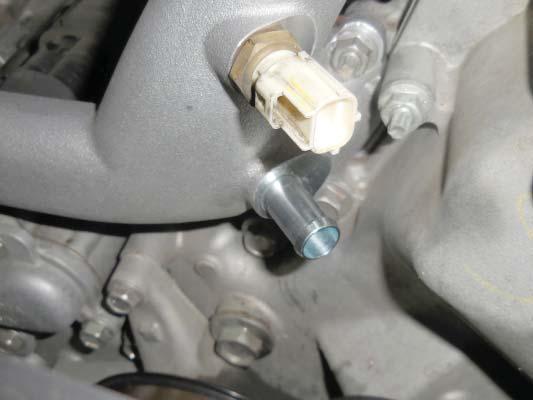 Use a 12 mm socket to remove the bolt shown with the blue