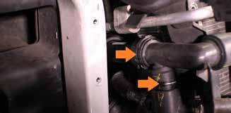 Disconnect the upper hose from the crossover pipe by pushing it back, then release the fitting from the thermostat housing by pulling upward.