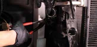 23. Compress the clamp that secures the coolant hose to the back of the passenger-side thermostat housing, and remove the hose from the housing. (1x spring clamp) 27.