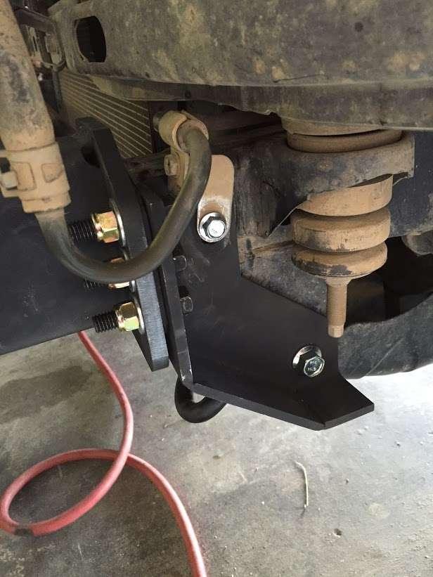 Install the supplied bumper bracket by slipping it behind the pressurized fluid line and loosely bolting it in using the supplied M12 bolt and M8