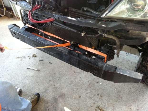 When the OEM bumper has been removed, you ll expose the cross beam that joins the frame rails together. Using a ratchet strap, apply slight tension around crash horn sections as shown.