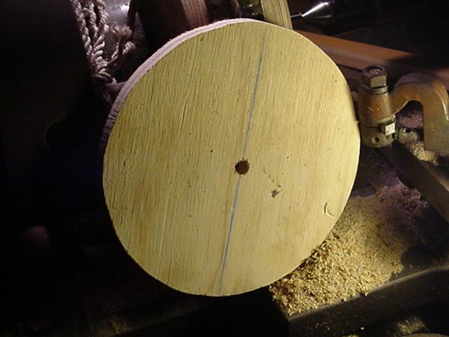 I cut out 5 plywood disks on a bandsaw, 9" diameter. In the center of each disc I drilled a 1/2" hole. These disks are laminated on the shaft to build up the armature.