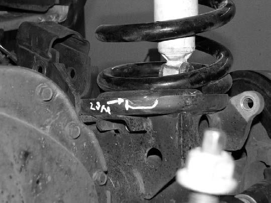 USE CARE TO NOT LIFT THE TRUCK OFF OF THE SUPPORT STANDS. Note: On some vehicles, the lower coil bucket must be notched for track bar bracket clearance. SEE PHOTO BELOW 11.