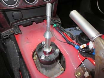21. Install the lockout plate on top of the spacer adapter. Locate the three provided hex-head bolts. Drop a bolt into each of the three holes in the top of the shifter. Tighten each bolt to 7.5 ft.