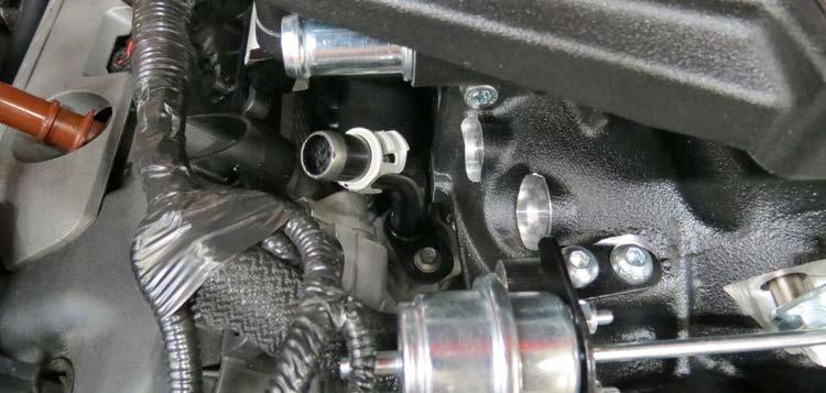 82. Reinstall the passenger side heater hose fitting using the factory