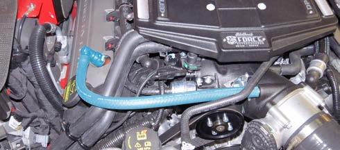 Using a 10mm socket, remove the top bolt securing the windshield wiper fluid