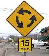 Yield to traffic already driving in the roundabout. Find a safe gap. Merge into the flow of traffic.