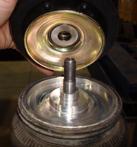 Once the coil spring tension is secure, unthread the upper mount nut and remove the nut and mount bushing from the assembly. Slowly release tension from the coil spring.