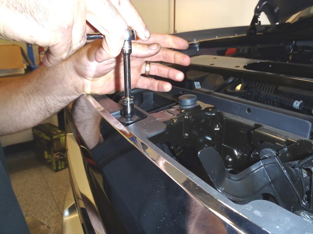 Pull up all fasteners and remove plastic radiator cover. Figure 4 Re-use factory hardware to attach the Lower Bracket to the tow hooks and frame. 7.
