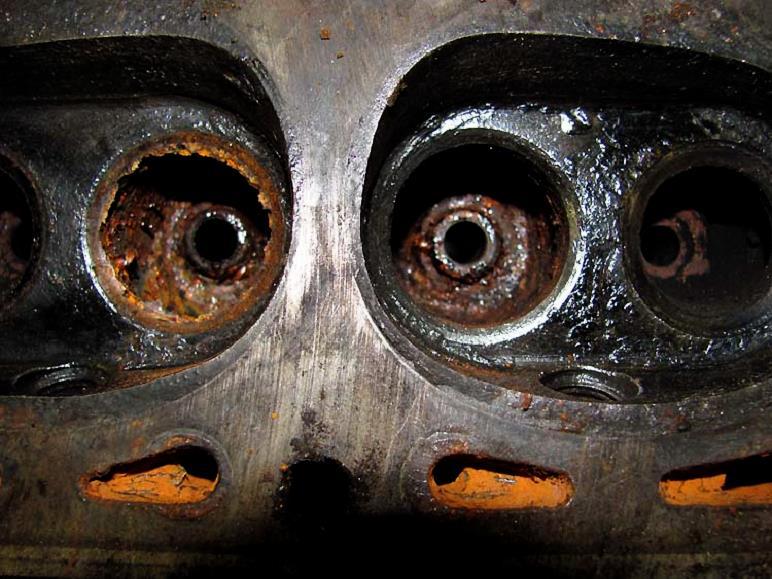 While we are inspecting the condition of this cylinder head, you can plainly see that, at some time, some of the combustion chambers were filled with water, which was