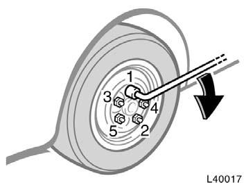 Lower the vehicle completely and tighten the wheel nuts. Turn the jack handle counterclockwise to lower the vehicle. Use only the wheel nut wrench to tighten the nuts.