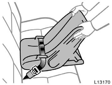 2. While pressing the infant seat firmly against the seat cushion and seatback, tighten the lap