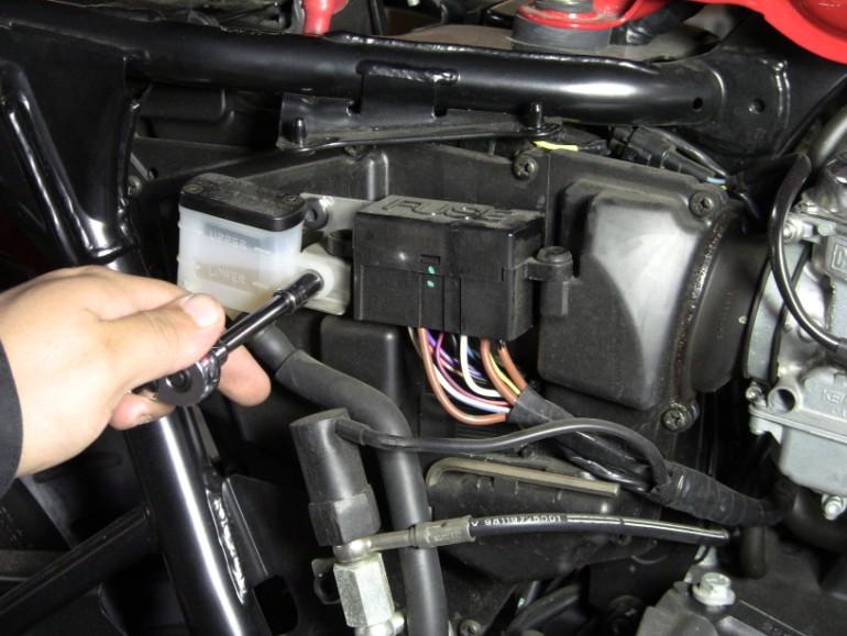 Step 6: Remove rear brake reservoir bolt by