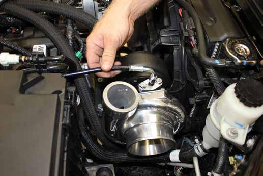 b. Using a long extension snug the turbocharger to the flange but do not tighten completely c.