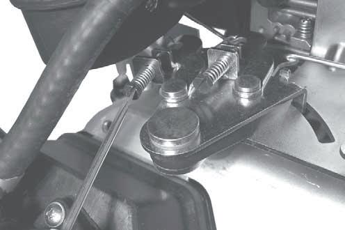 Hold the governor lever away from carburetor so the throttle lever is against the Idle Speed (RPM) Adjustment Screw of carburetor. See Figure 25.