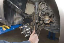 Install the strut mounting bolts that attach the steering knuckle to the strut assembly and