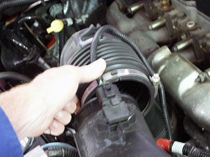 1. Using a flat head screwdriver, loosen the band clamp that holds the intake tube onto the stock filter housing. Disconnect the intake tube from the intake housing. Removing the Stock intake 2.