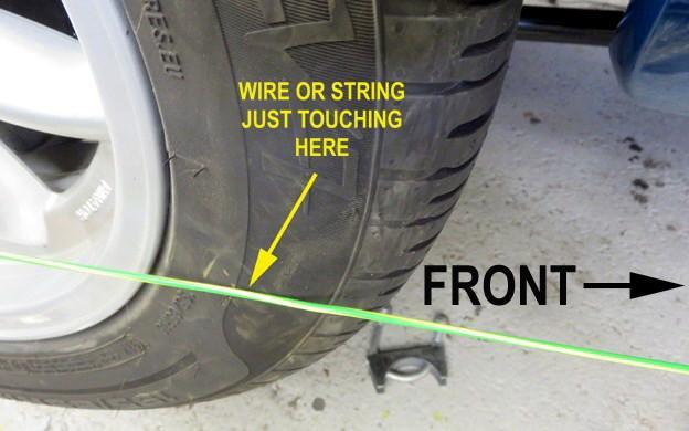 Then you get your beautiful assistant to look at the widest part of the tyre and you move the axle stand carefully towards, or away from the centre of the