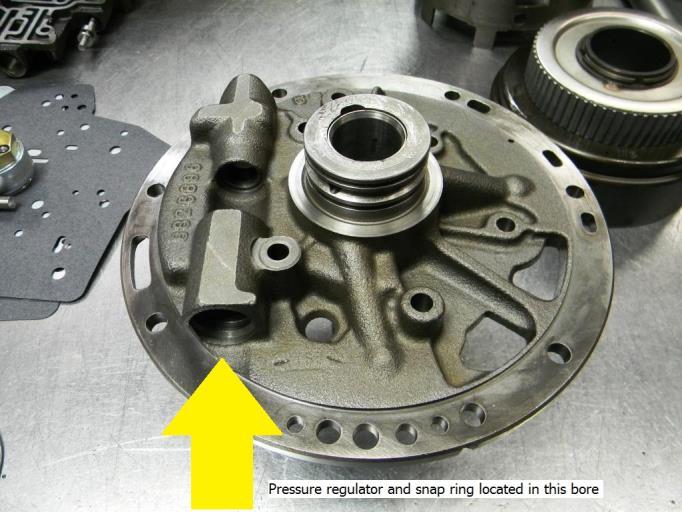 6. Locate the pressure regulator snap ring that retains the pressure regulator assembly in the front pump (see figure 3A). (Figure 3A) Apply pressure to the booster sleeve and remove the snap ring.