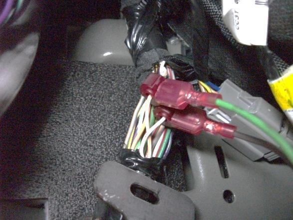 Find the twisted pair of wires that are white and white/brown stripe in the wire harness above the parking brake.