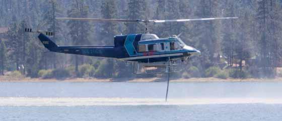 The aircraft is a four bladed, twin engine helicopter. For water or retardant delivery, the S-70 can have a large tank mounted on the bottom or can carry a bucket.