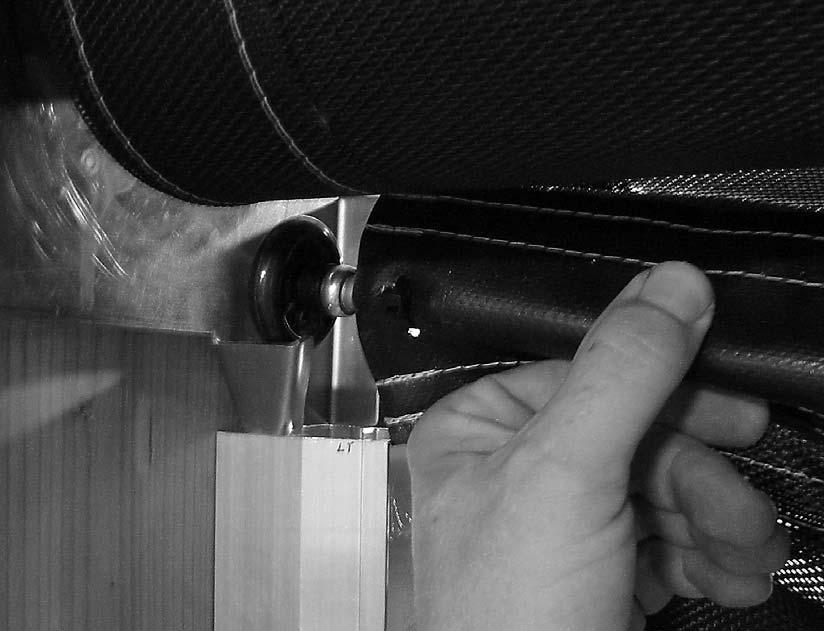 Raise the roller up, slide it across the face of the Motor or Idler bracket, and drop it into the funnel of the bracketry as shown in the following photo (Photo 13): Photo #13 (Roller Into Funnel)