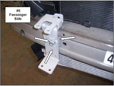 Insert the top of the passenger side clamp bracket through the gap between the impact beam and auxiliary cooler, and then rotate the bracket into position.