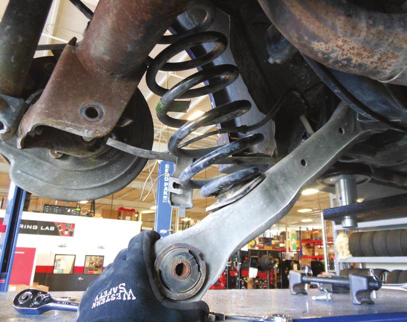 Support the lower control arm and remove the bolt attaching it to the axle.