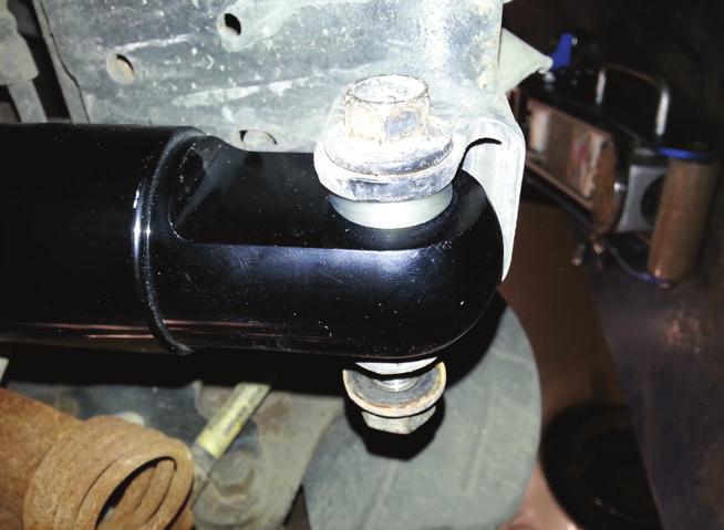 6. Remove the shock rod nut, upper washer and bushing from the new shock.