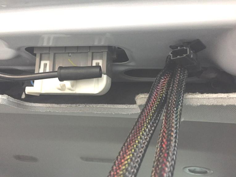 Route harness behind the plastic panel to desired location.