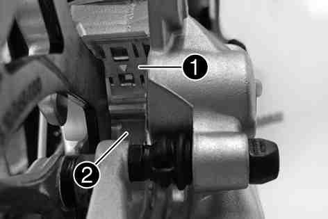 Make sure when pushing back the brake piston that you do not press the brake caliper against the spokes. Remove locking split pins, withdraw bolt, and take out the brake linings.