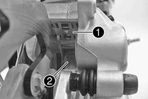 Make sure when retracting the brake piston that you do not press the brake caliper against the spokes. Remove locking split pins, withdraw bolt, and take out the brake pads.