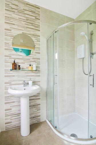 FULLY TILED MODERN ENSUITE SHOWER ROOM: Fully tiled shower cubicle with electric shower, low