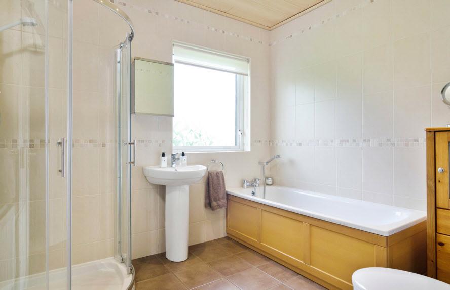 MODERN FITTED BATHROOM: White suite comprising panelled bath with shower attachment, low flush wc, pedestal wash hand
