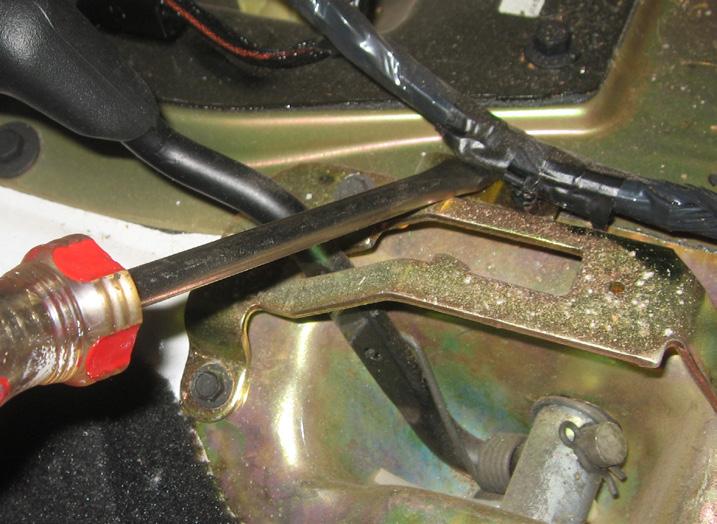 6. Using a flathead screwdriver, remove the wire loom connector clip from the transfer case shifter bracket.