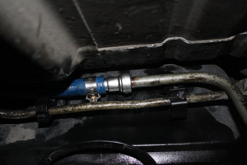 Using a fuel line disconnect tool, disconnect the factory suction line located above the fuel cooler.