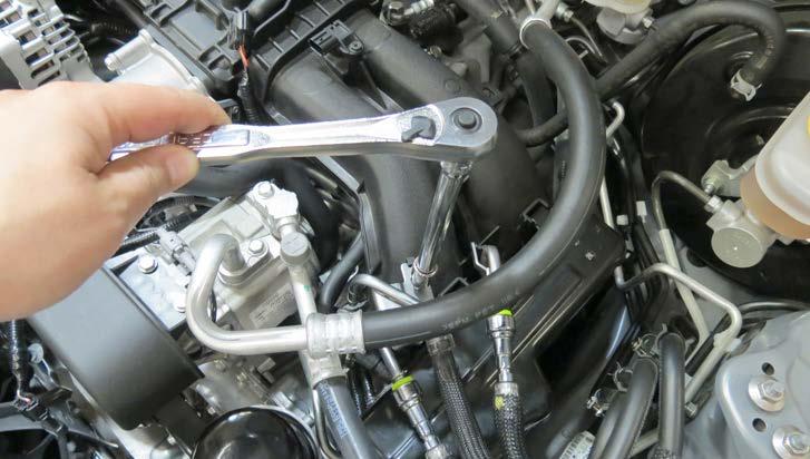 Release the blue locking clip located on the fuel crossover line and carefully remove the