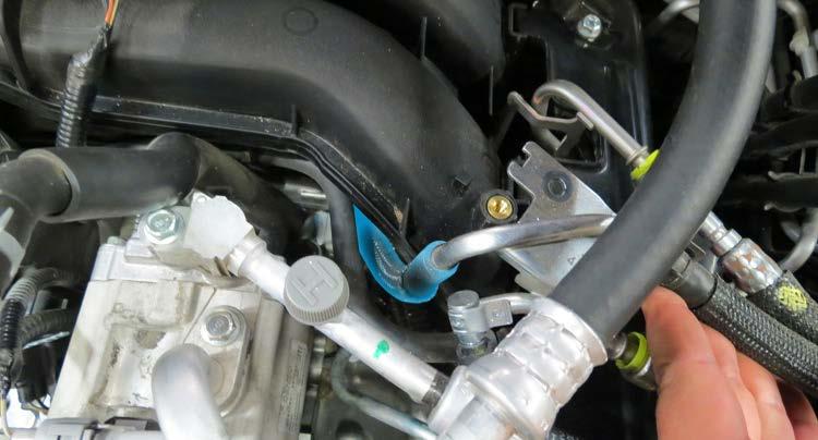Remove the plastic rivet securing the fuel injector harness to the fuel rail using needle